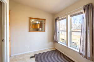 Empty room featuring a healthy amount of sunlight, visible vents, and baseboards