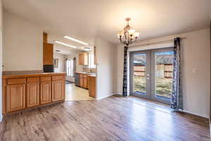 Kitchen featuring light wood-style floors, french doors, plenty of natural light, and stainless steel dishwasher