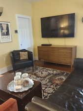 Living room with visible vents, baseboards, and dark wood finished floors