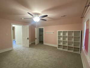 Unfurnished bedroom featuring a ceiling fan, carpet, visible vents, and baseboards