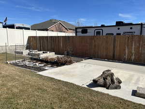 View of yard featuring a patio, a vegetable garden, and fence