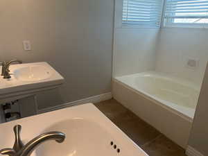 Full bathroom featuring baseboards and a washtub