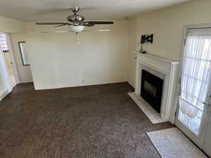 Family Room featuring a tiled fireplace, light colored carpet, and ceiling fan