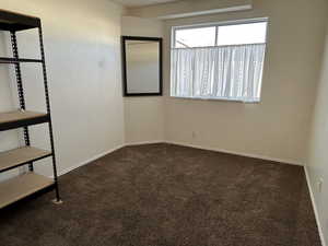 Carpeted spare room featuring baseboards