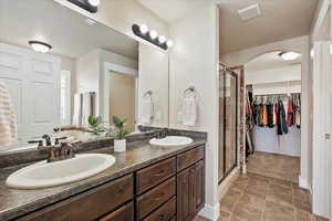 Full bathroom with visible vents, a stall shower, and a sink