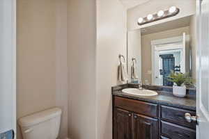 Bathroom featuring visible vents, toilet, and vanity