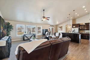 Living area featuring a ceiling fan, baseboards, lofted ceiling, recessed lighting, and light wood-type flooring