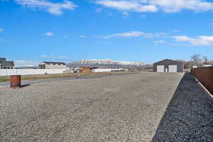 View of yard with an outdoor structure, a garage, fence, and a mountain view