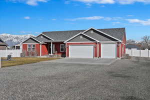 View of front of home featuring fence, a garage, and driveway