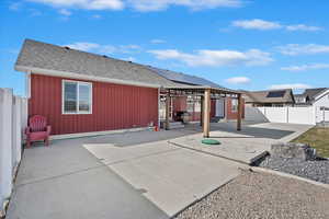 Rear view of house featuring a fenced backyard, a patio, and roof with shingles