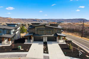 View of front facade featuring a mountain view, a garage, and concrete driveway