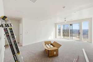 Unfurnished living room with carpet floors and a ceiling fan