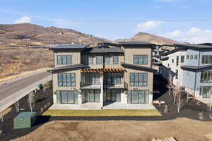 Rear view of house with a patio area, board and batten siding, and a mountain view