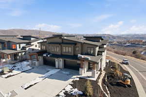 View of front of property with a mountain view, a garage, driveway, and a residential view