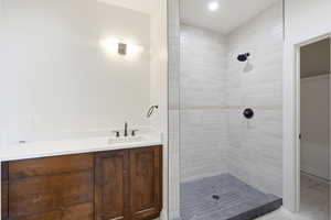 Bathroom featuring vanity and a tile shower