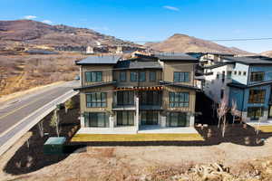 Rear view of property featuring a patio area, a mountain view, and roof with shingles