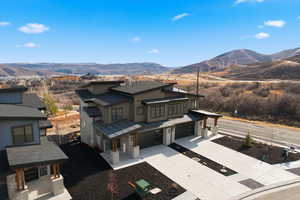 View of front facade with a mountain view, a garage, concrete driveway, and a porch