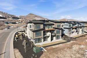 Back of property featuring a residential view, a mountain view, and a patio area