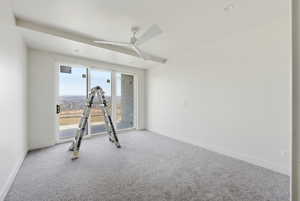 Exercise area featuring a ceiling fan and carpet
