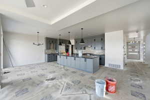 Kitchen featuring gray cabinets, a large island, decorative light fixtures, and open floor plan