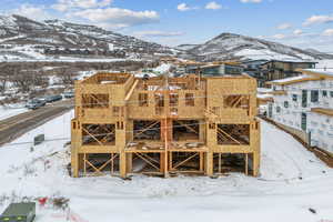 Snow covered property with a mountain view and a residential view