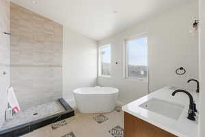 Bathroom with double vanity, a soaking tub, and vaulted ceiling