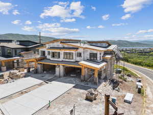 View of front of house with a carport, a mountain view, and concrete driveway