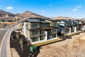Back of property with a mountain view, a residential view, a patio area, and a balcony