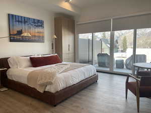 Bedroom with access to exterior and wood finished floors