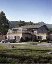 View of front facade with a mountain view, a garage, and a front yard