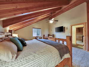 Carpeted bedroom featuring lofted ceiling with beams and a ceiling fan