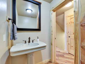 Bathroom with visible vents, a sink, baseboards, and wood finished floors