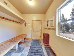 Mudroom with visible vents, stone finish floor, and baseboards