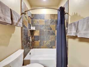 Full bath with toilet and shower / tub combo with curtain