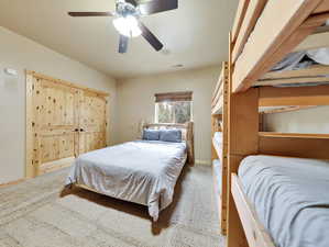 Carpeted bedroom featuring visible vents, baseboards, and ceiling fan