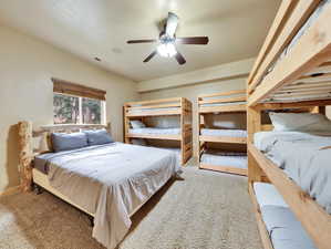 Carpeted bedroom with visible vents, baseboards, and ceiling fan
