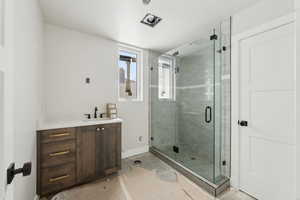 Bathroom with baseboards, vanity, and a shower stall