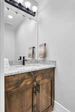 Bathroom featuring visible vents, vanity, and baseboards