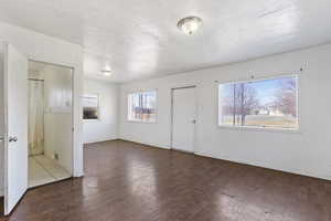 Foyer entrance with baseboards, a textured ceiling, and hardwood / wood-style floors