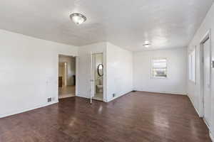 Unfurnished room with visible vents, a textured ceiling, and wood finished floors