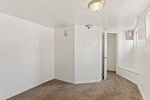 Unfurnished room featuring carpet flooring, visible vents, and a textured ceiling