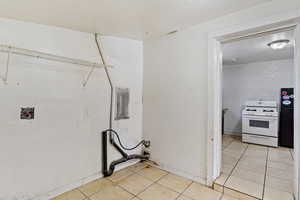 Clothes washing area featuring hookup for a washing machine, light tile patterned flooring, and laundry area