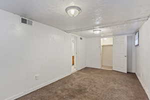 Interior space with baseboards, visible vents, and a textured ceiling