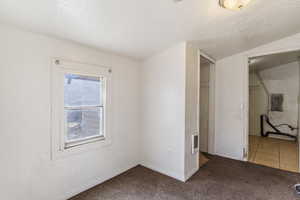 Unfurnished bedroom with baseboards, visible vents, a textured ceiling, and carpet