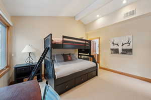 Carpeted bedroom with recessed lighting, visible vents, vaulted ceiling with beams, and baseboards