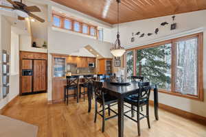 Dining space with a wealth of natural light, wood ceiling, baseboards, and light wood finished floors