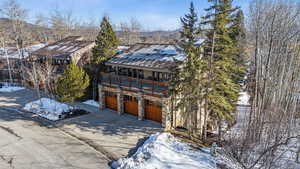 View of front of house with concrete driveway, an attached garage, and stone siding