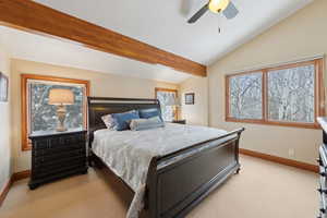 Bedroom with lofted ceiling with beams, ceiling fan, baseboards, and light colored carpet