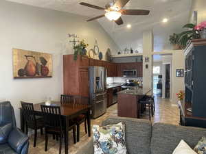 Kitchen featuring a center island, open floor plan, light tile patterned floors, stainless appliances  and a kitchen breakfast bar