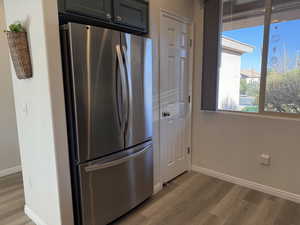 Kitchen with baseboards, light wood finished floors, and freestanding refrigerator